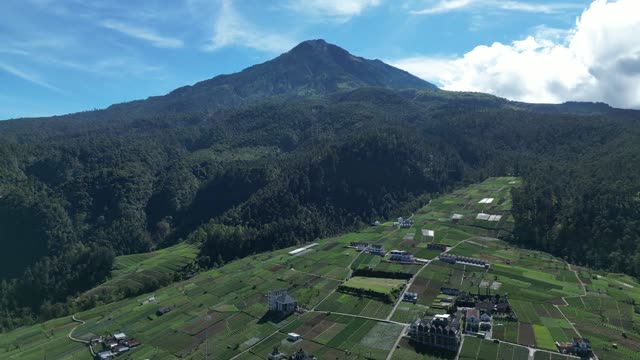 Stunning aerial panorama of a lush mountain landscape with clear skies.