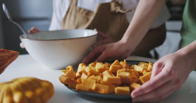 Enjoy a cozy family baking session with mom and daughter preparing a pumpkin dish.
