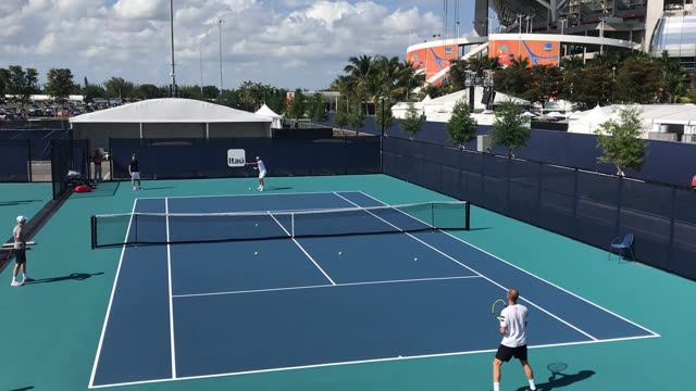 Players engaged in a vibrant tennis match on a sunny day.