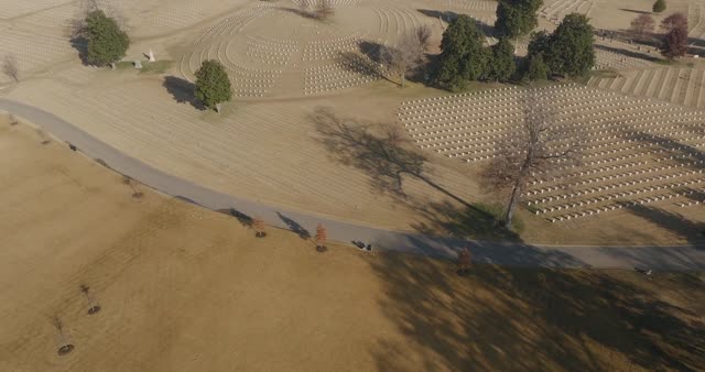 Drone footage capturing a serene aerial view of a veterans cemetery with trees and fields.