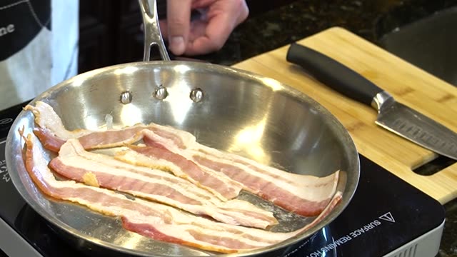 Close-up of bacon sizzling in a pan. Ideal for cooking visuals.