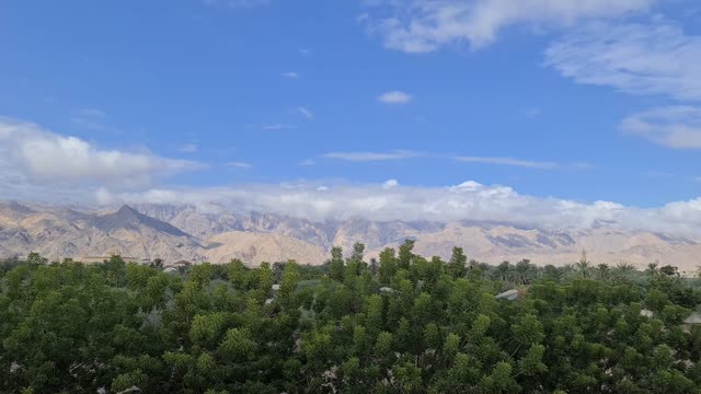 A breathtaking view of mountains under a vivid blue sky with lush greenery.