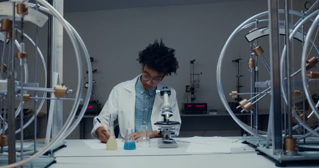 African American student conducting science experiment with colored liquids.