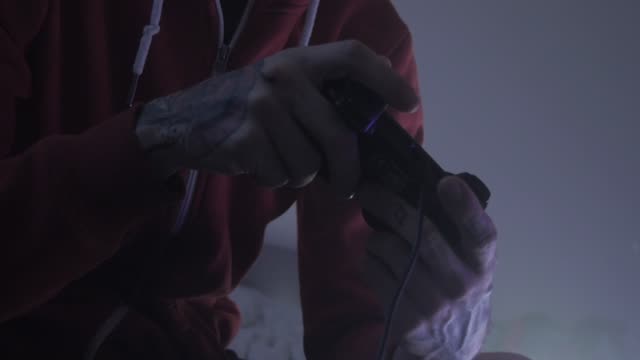 A man intensely gaming indoors, focused and engaging.