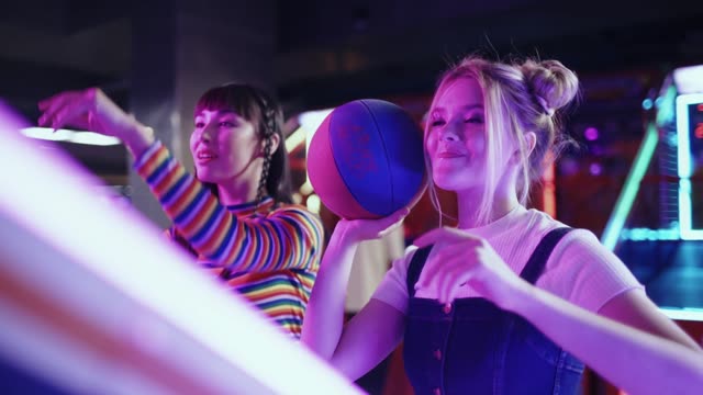 Teens enjoying arcade games with neon lights and laughter.