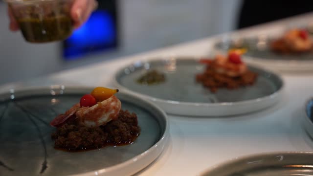 Close-up of gourmet shrimp plating with decorative sauce.