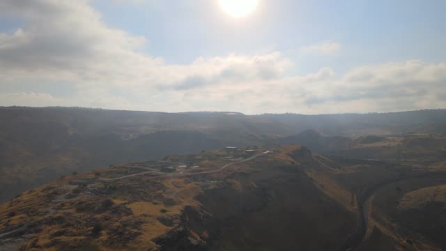 Drone footage of ancient archaeological ruins in Golan Heights under sunny skies.
