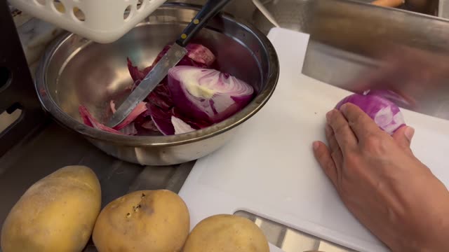 Watch a smooth technique for slicing red onions in the kitchen.