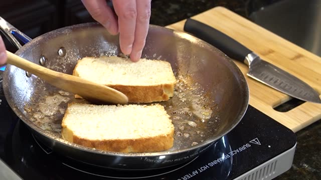 Hands flipping toast slices in pan with spatula. Ideal for cooking scenes.