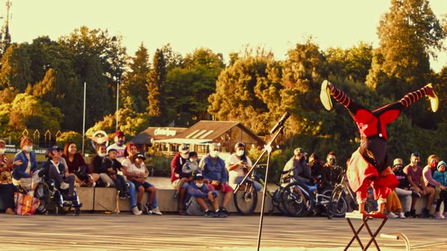 Vibrant street performer captivates an audience during a lively outdoor show.