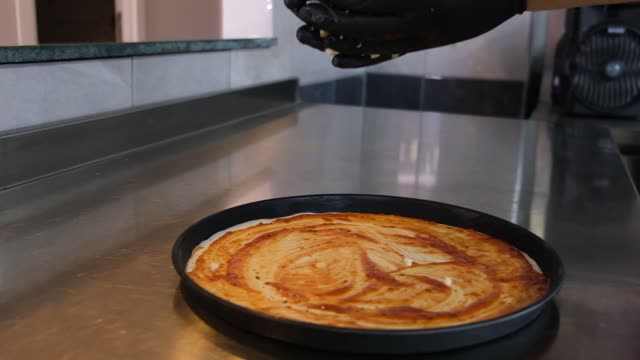 Chef preparing delicious homemade cheese pizza in a commercial kitchen. 