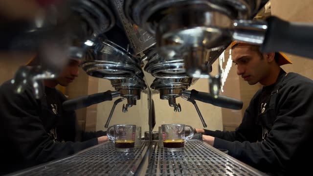 Close-up of a barista expertly making espresso at a chic cafe.