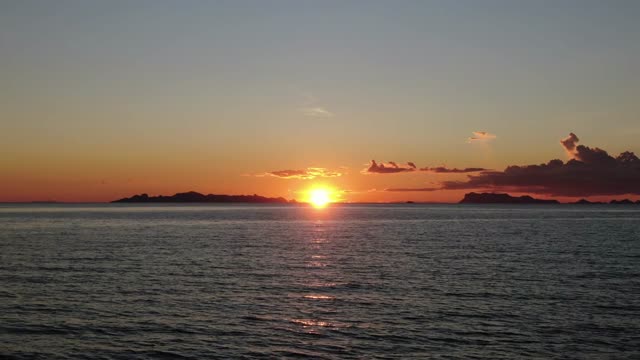 Breathtaking ocean sunset with vibrant colors and scenic islands on the horizon.