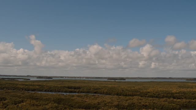 Dynamic timelapse capturing a serene coastal landscape under shifting clouds.